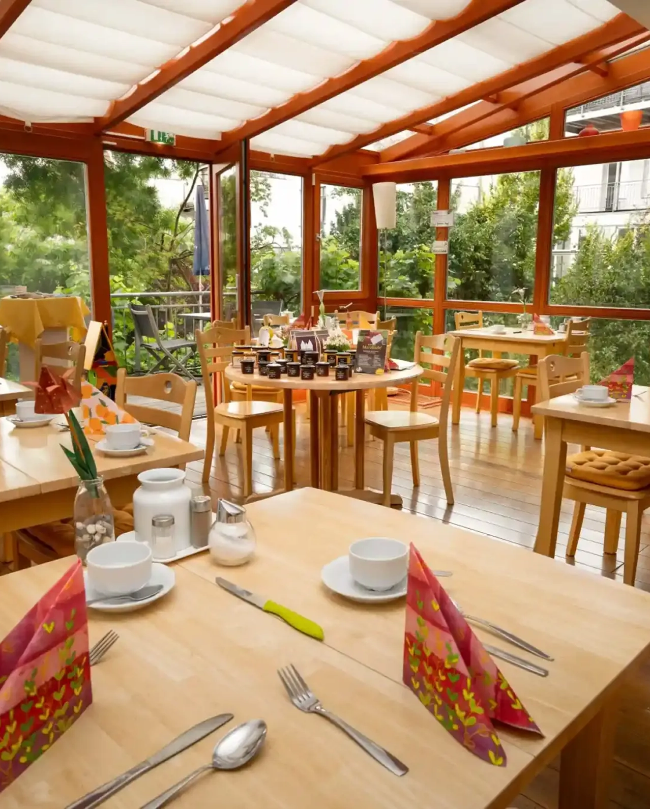 Frühstücksraum im Wintergarten mit gedeckten Tischen