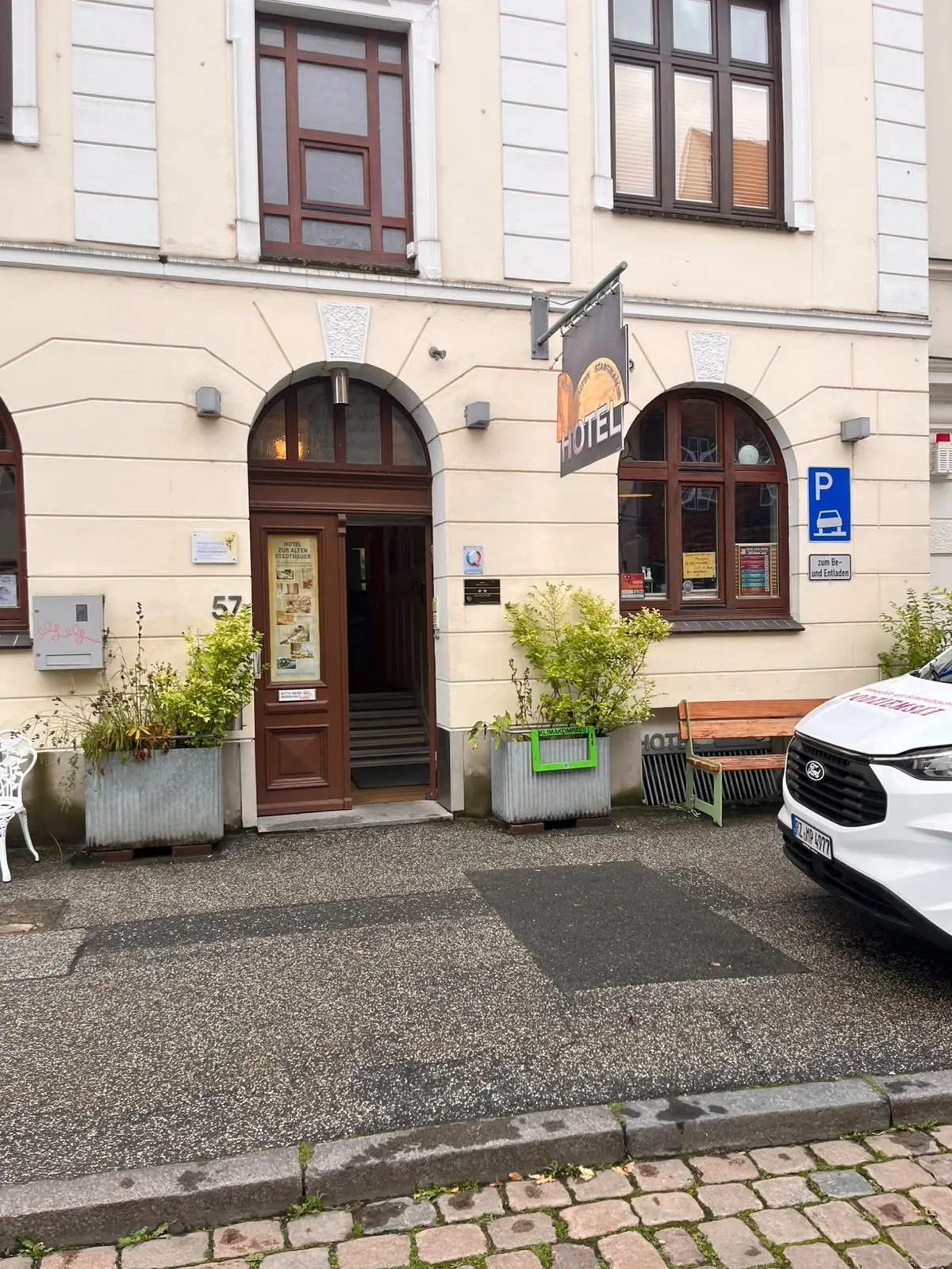 Grüner Klimakompass-Rahmen mit QR-Code im Pflanzkübel vor dem Hotel zur alten Stadtmauer in Lübeck